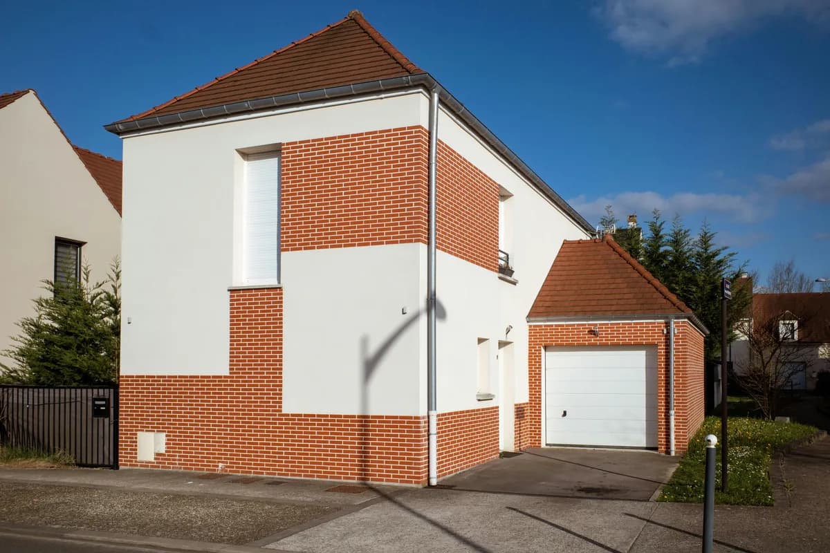 Modern brick and white residential house with large windows and garage