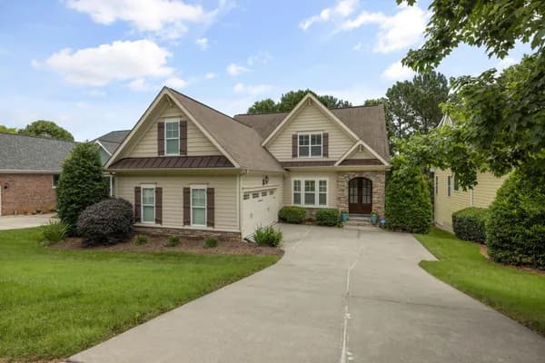 Two-story residential house with multiple windows and stone accents
