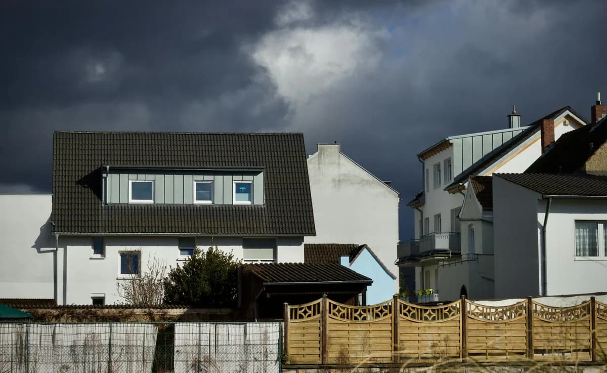 Modern white house with dark roof and decorative wooden fence gate
